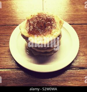 Stapel von Buttermilch Pfannkuchen mit Sirup über ihnen ausgegossen wird. Stockfoto