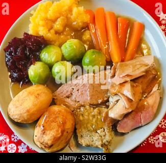 Weihnachten Truthahn Abendessen serviert in einem hellen Platte mit einem roten Unterlage Stockfoto