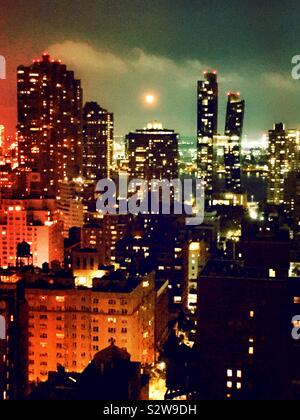 Vollmond über den East River, als von einem Dach in Midtown Manhattan Viertel Murray Hill, New York, USA Stockfoto