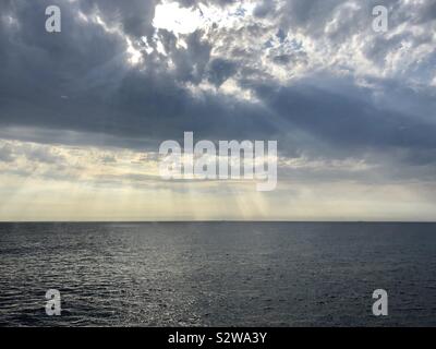 Sonnenlicht durch Wolken über dem Meer Stockfoto