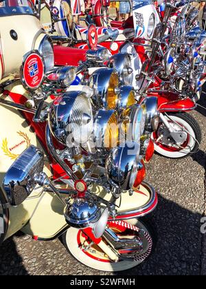 Licht fantastische - Maßgeschneiderte Motorroller an der Strandpromenade geparkt als Mods aus ganz Großbritannien für die jährliche August Bank Holiday Mod Weekender Rallye in der Sonne sammeln. Stockfoto