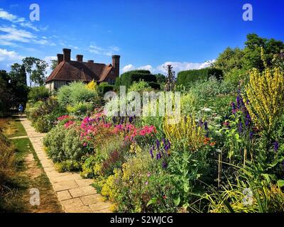 Staudenpäonien Blume Grenze im Sommer am Great Dixter in East Sussex, wahrscheinlich die besten englischen Cottage Gärten. Stockfoto