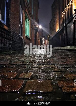 St Martins Osten in Leicester bei Nacht, mit den nassen Kopfsteinpflaster hinter der Kathedrale in der Altstadt Stockfoto