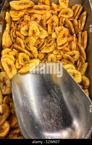 Viele getrocknete Bananenchips in einen Eimer mit einer Schaufel. Stockfoto