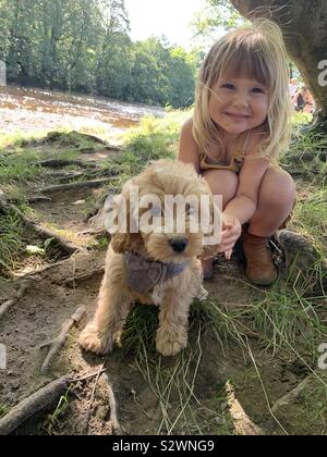Kleine blonde Mädchen und einen Welpen Stockfoto