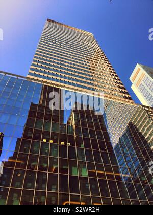 Reflexionen der Wolkenkratzer auf die glasfassade von 300 Madison Ave Hauptquartier für Price Waterhouse Coopers LLP wirtschaftsprüfungsfirma an der 42 St. in Midtown Manhattan, New York City, USA Stockfoto