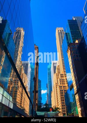 Wolkenkratzer und ihre Überlegungen in einem Canyon der Gebäude auf der Suche nach Westen auf der 42th St., Midtown Manhattan, New York City, USA Stockfoto