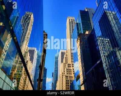 Reflexionen der Wolkenkratzer in der Schlucht von Gebäuden entlang der 42nd St., New York, USA Stockfoto