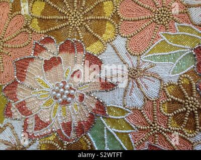 Perlenverzierten Blumenmotiv mit Erdtönen. Stockfoto