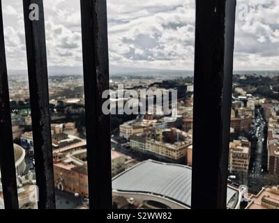 Stadt Rom gesehen durch Bars im Fenster auf die Kuppel des Petersdoms Stockfoto