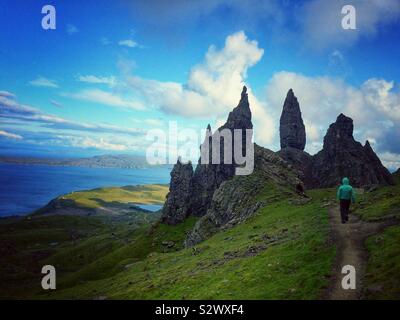 Ansicht von hinten von einem Mann gehen auf einem schmalen Eid steigende die dramatische Landschaft od Der alte Mann von Storr, Skye Isle, Schottland Stockfoto