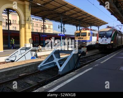 Keleti palyaudvar (Bahnhof) Budapest, Ungarn. Elektrolokomotiven am Pufferpunkt stoppen den Anschlagpunkt und zwei Zugbegleiter gehen zu Fuß. Stockfoto
