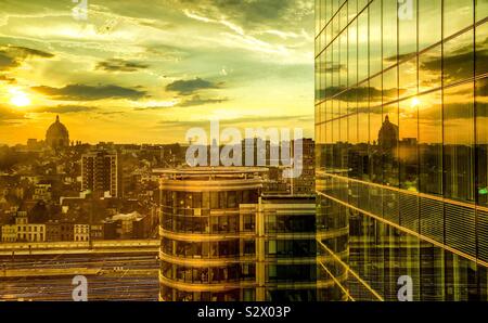 Am frühen Morgen Sonnenaufgang in einem dramatisch und bunten Himmel, im Glas ein Bürogebäude im Finanzviertel der Stadt wider Stockfoto