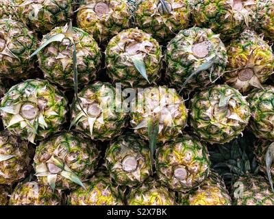 Viele reife Ananas zum Verkauf gestapelt. Stockfoto