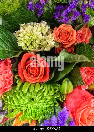 Schönen Sommer Strauß voller Orangen Rosen, Chrysanthemen, und Blätter. Stockfoto