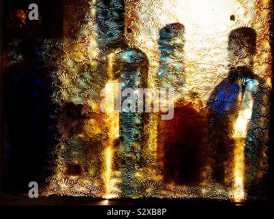 Beleuchtete Flaschen Spirituosen in einer Bar durch Glas gemusterten Bereich. Nancys's Bar, Ardara, County Donegal, Irland Stockfoto