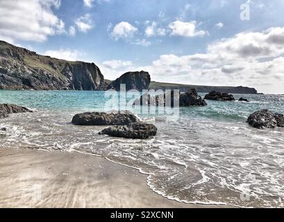 Blick vom Strand auf den Atlantischen Ozean, die Felsen und Klippen im Hintergrund - Kynance Cove, Cornwall, Großbritannien Stockfoto