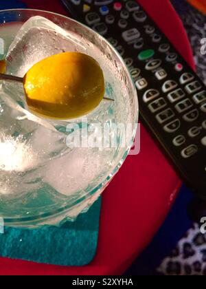 Nahaufnahme eines Martini auf den Felsen in einem Kristall Glas neben einer TV-Fernbedienung, USA Stockfoto