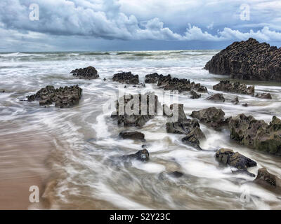 Wellen waschen um Felsen auf ein Waliser Surf Beach, Gower, Oktober. Stockfoto