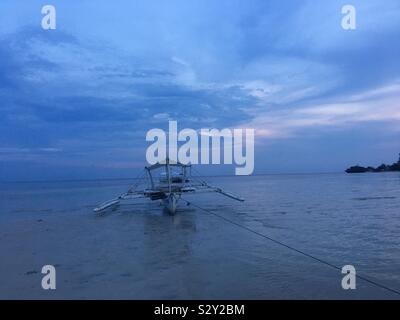 Ein Boot in Ruhe am Strand bei Sonnenuntergang Stockfoto