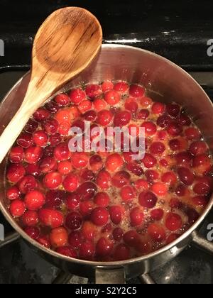 Die hausgemachte Preiselbeersoße. Kochen Cranberries in einem Topf Soße zu erhalten. Stockfoto