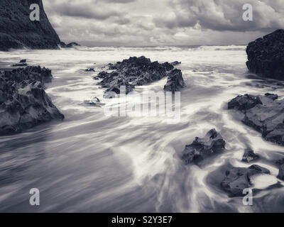 Wasser hetzen durch die Felsen, die Tide surge abfließt, Mewslade, Gower, Wales. Stockfoto