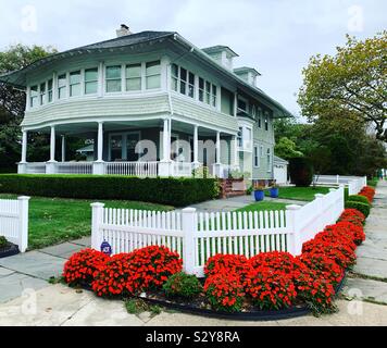 Orange Blumen und einem weißen Zaun vor einem Haus in Allenhurst, Monmouth County, New Jersey, United States Stockfoto