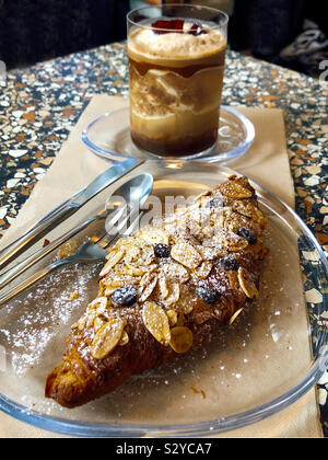 Kaffee und Mandel Croissant auf Tisch Stockfoto