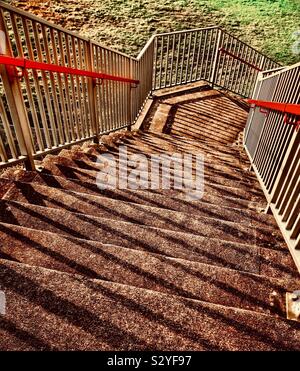 Unten Betontreppen mit starken Schatten und Metall Handläufe Stockfoto