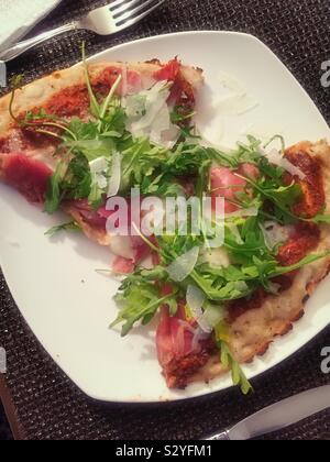 Zwei Scheiben Rucola und Tomate garniert Pizza Stockfoto