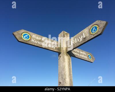 Drei weise Holz- Wegweiser, im Norden von Wales, gegen einen strahlend blauen Himmel. Stockfoto