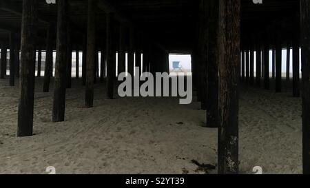 Blau lifeguard Tower in Nebel, durch unterstützt von hölzernen Pier am Pismo State Beach in Kalifornien gesehen Stockfoto