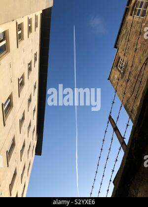 Auf der Suche nach einer Jet overhead zwischen städtischen Gebäuden Stockfoto