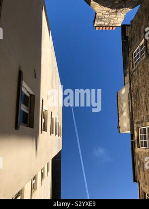 Auf der Suche nach einer Jet overhead zwischen städtischen Gebäuden Stockfoto