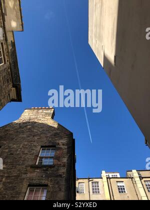 Auf der Suche nach einer Jet overhead zwischen städtischen Gebäuden Stockfoto