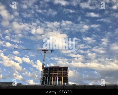 LOS ANGELES, Ca, May 2019: Kran und neue Wohnung Bau in der Innenstadt, vereinzelte Wolken im blauen Himmel hinter Stockfoto