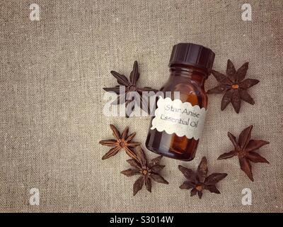 Flasche ätherische Öl und Sternanis auf einer Leinwand Hintergrund mit Platz kopieren. Stockfoto