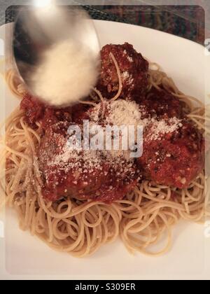 Ein Diner bestreuen geriebenen Parmesan auf Spaghetti mit Fleischbällchen entrée Stockfoto