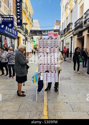 Alte Dame Kauf eines Lottery Ticket von einem Straßenhändler in Spanien Stockfoto