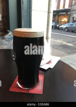 Pint Murphy's Stout Bier auf der Tabelle im Fenster der Bar Isaacs, Cork Irland Stockfoto