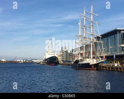 Royal Yacht Britannia und neben einer hohen Schiff vertäut im Hafen von Leith, Edinburgh, Schottland Stockfoto