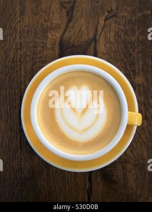 Tasse Cappuccino mit Latte Art auf einem Holztisch Stockfoto