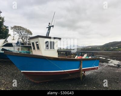 Ein altes Fischerboot auf dem Schlamm bei Ebbe im Loch Portree, Portree auf der Insel Skye Litze Stockfoto
