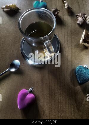 Close-up Tasse Tee mit farbenfrohen Herzen, getrocknete Blätter und Löffel. Stockfoto