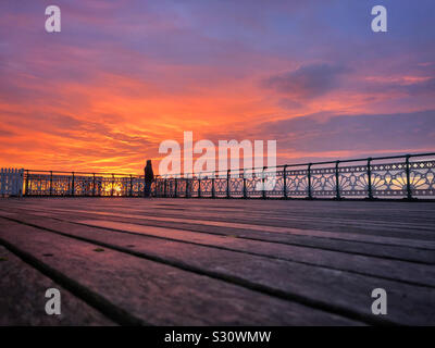 Lone Fischer bei Sonnenaufgang auf Penarth pier, Dezember. Stockfoto