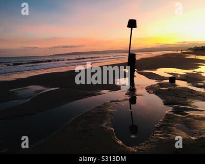 Großbritannien, England, Dorset, Poole, Branksome, Strand, Ebbe Sand, attraktive Formen, groyne, schönen Sonnenuntergang. Stockfoto