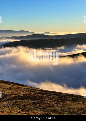 Wolken über die Brecon Beacons, am frühen Morgen, Dezember. Zuckerhut in der Ferne. Stockfoto
