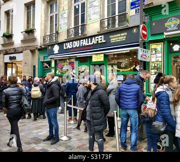 Traditionelle Schlange von Kunden bei "L'Wie du Fallafel" Restaurant in Le Marais, Paris, Frankreich. Stockfoto