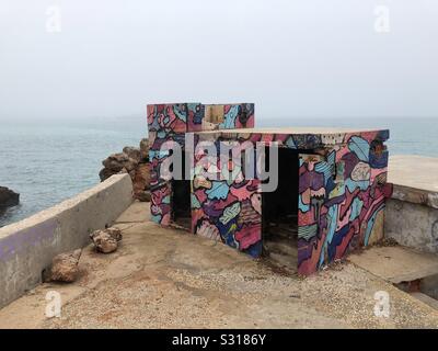Alte Gebäude aus Beton durch das Meer in Graffiti bedeckt Stockfoto