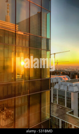 Sonnenuntergang über dem Geschäftsviertel der Stadt, wo die Sonne scheint durch die Fenster eines Bürogebäudes Stockfoto